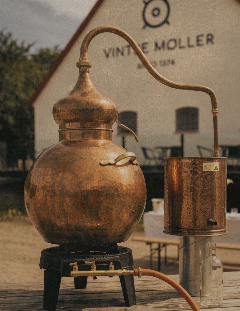 A small copper pot still set up outdoors at Vintre Møller.